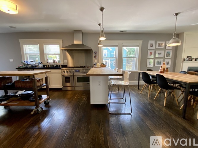 A modern kitchen with dark wood floors and white cabinetry.