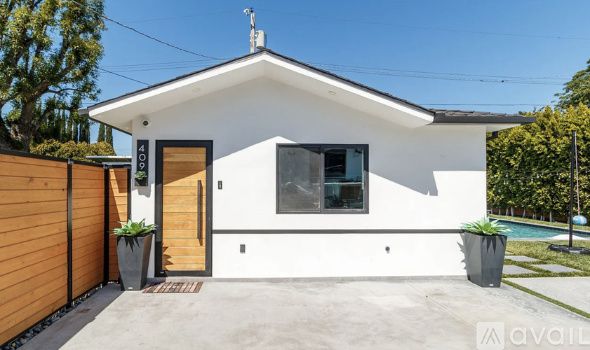 A modern house with a white exterior and a brown fence.