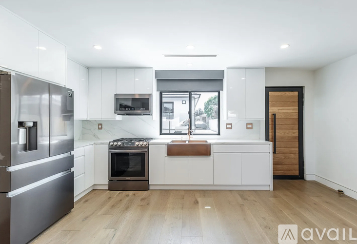 A modern kitchen with stainless steel appliances and white cabinetry.