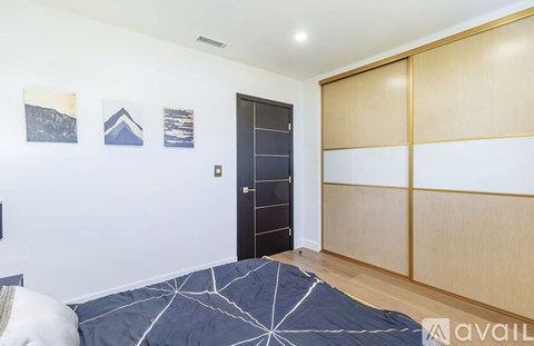 A bedroom with a bed and pictures on the wall.