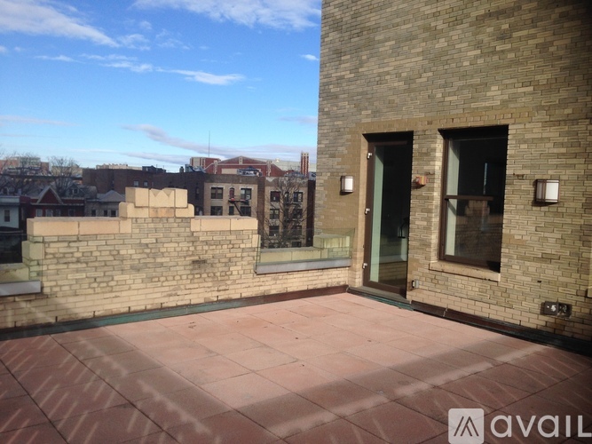 A brick building with a balcony and a view of the city.