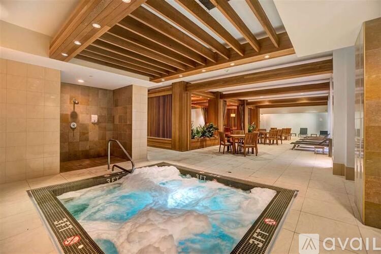 A hot tub in a room with wooden beams on the ceiling.