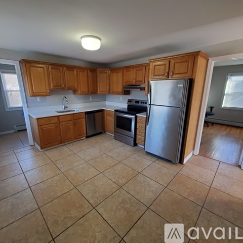 A kitchen with wooden cabinets and a refrigerator.