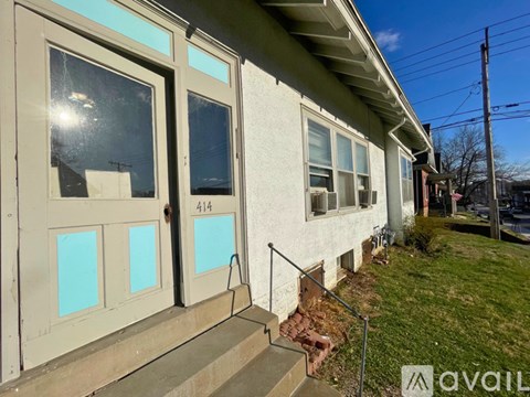 A house numbered 414 has a white door and windows.