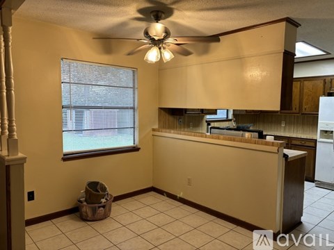 A kitchen area with a counter and a window with blinds.