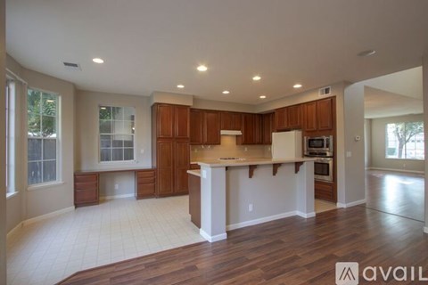 A kitchen with wooden cabinets and a white island.