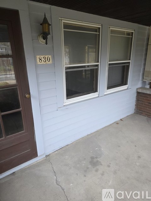 A house numbered 830 with a brown door and two windows.