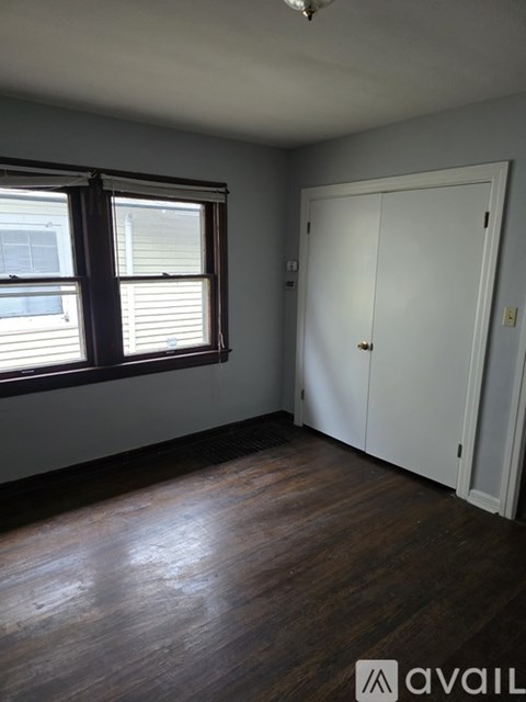 A room with a white door and a window with blinds.