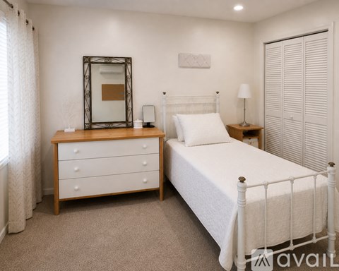 A bedroom with a bed, dresser, and mirror.