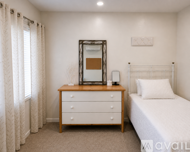 A bedroom with a bed, dresser, and mirror.