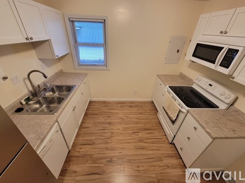 A kitchen with white cabinets and a window.