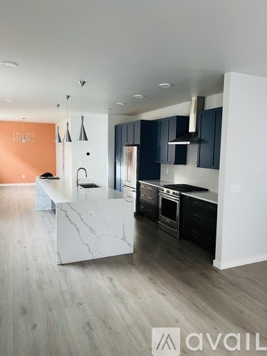 A modern kitchen with a marble island and stainless steel appliances.