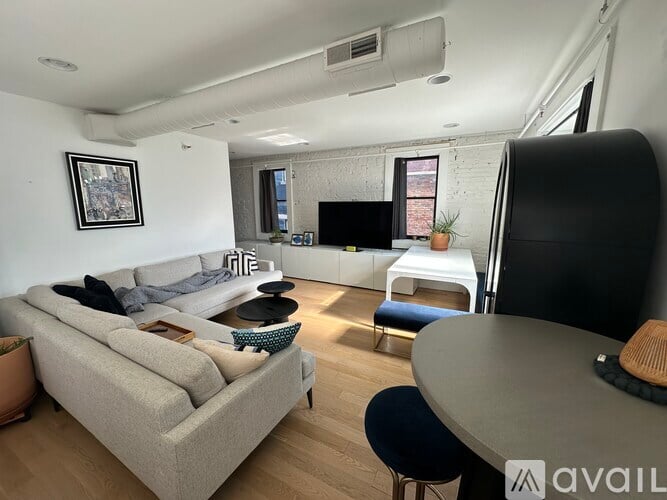 A living room with a grey couch and a black chair.