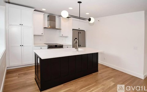 A kitchen with white cabinets and a dark counter.