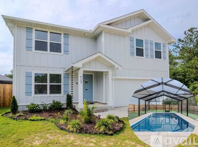 A white house with a blue door and a pool in the backyard.