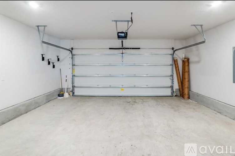 A large garage with a white door and a grey floor.