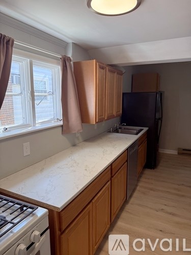 A kitchen with wooden cabinets and a marble countertop.