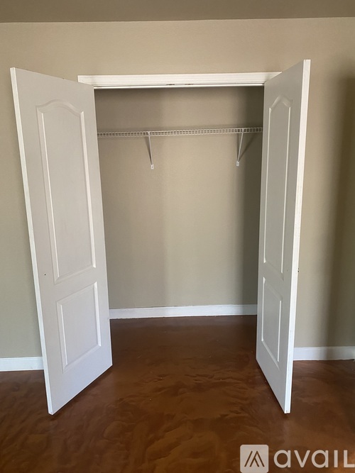 A white closet with a hanger rod and two doors.