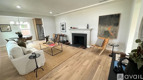 A living room with a fireplace and a painting on the wall.