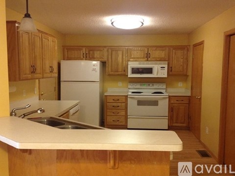 A kitchen with wooden cabinets and white appliances.
