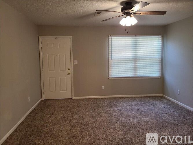 A room with a ceiling fan and a door.