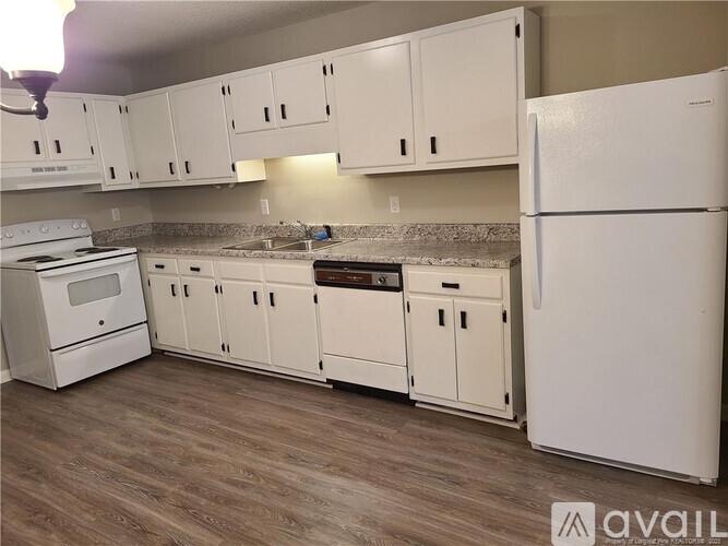 A kitchen with white appliances and cabinets.