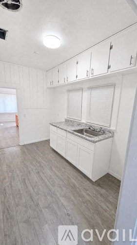 A kitchen with white cabinets and a marble countertop.