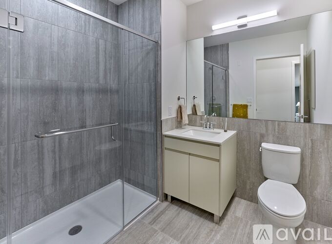 A bathroom with a walk-in shower, a toilet, and a sink.