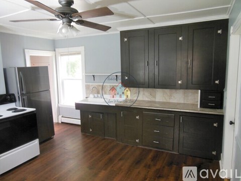 A kitchen with black cabinets and a white stove top oven.