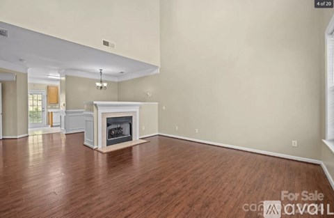 A living room with a fireplace and wood flooring.