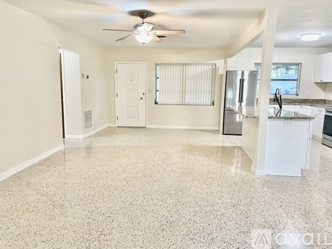 A kitchen with white cabinets and a countertop with a refrigerator, microwave, and oven.