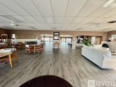 A spacious living room with a white sofa and wooden flooring.