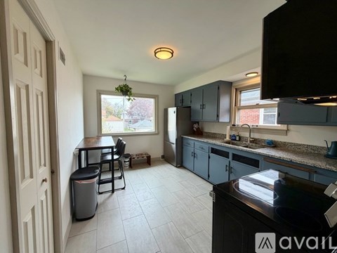 A kitchen with a black countertop and a window with a view of a tree.