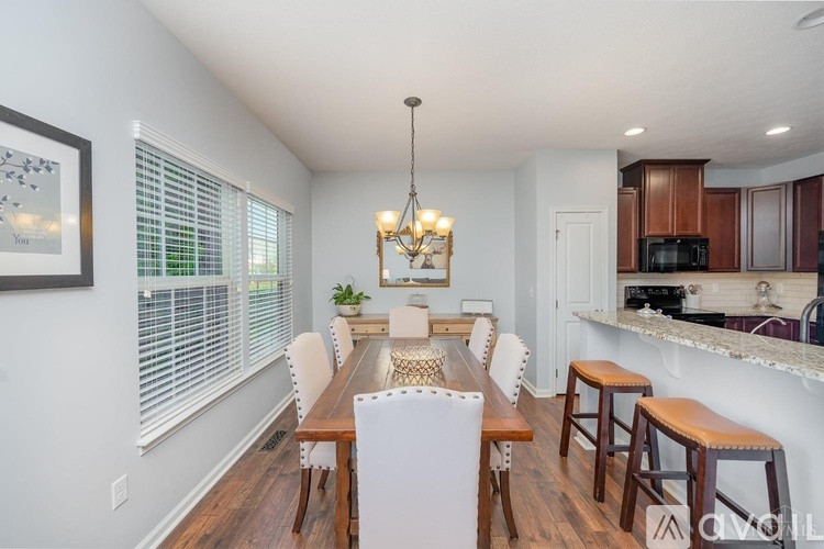 A dining room with a white table and chairs.