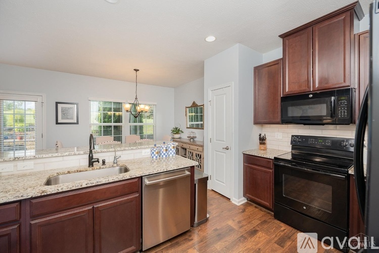 A kitchen with dark wood cabinets and stainless steel appliances.