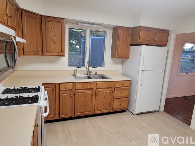 A kitchen with wooden cabinets and a white refrigerator.
