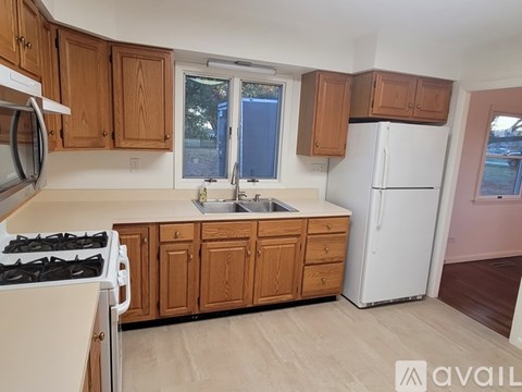 A kitchen with wooden cabinets and a white refrigerator.