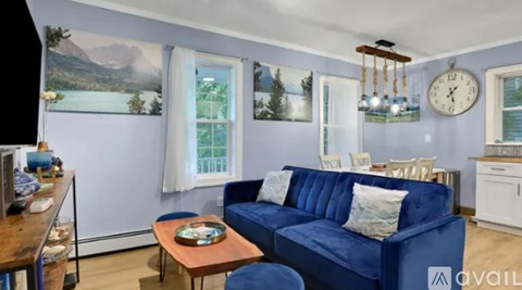 A living room with a blue couch and a wooden coffee table.
