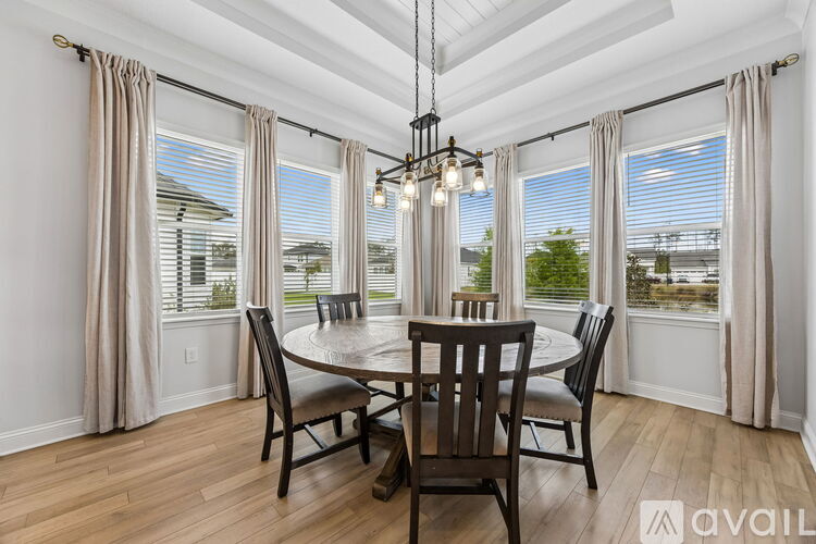 A dining room with a round table and chairs.