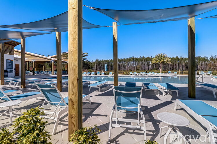 A sunny day at the outdoor pool area with blue chairs and tables.