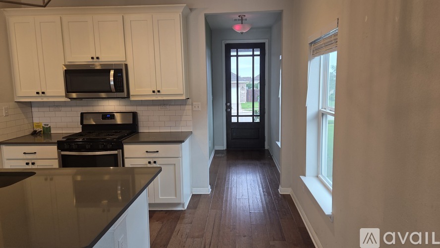 A kitchen with white cabinets and a black stove top oven.