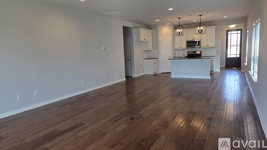 A white door is in a hallway with a brown floor.