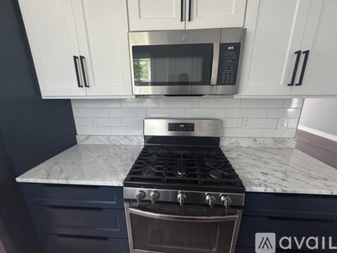 A modern kitchen with a stove top oven and microwave above it.