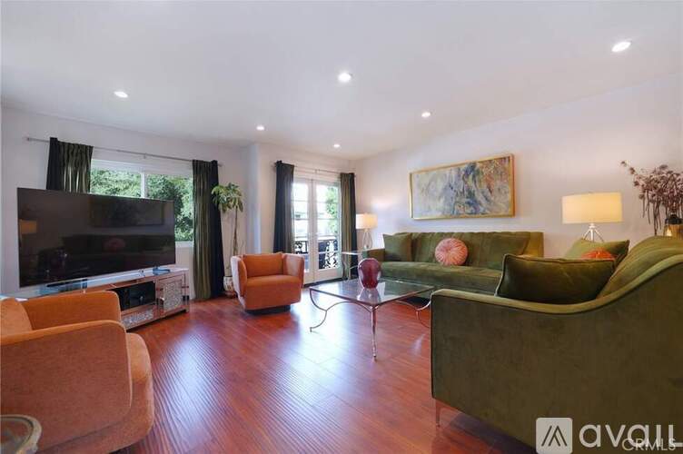 A living room with a green couch and a television.