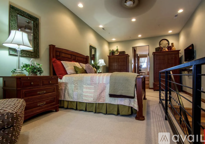 A bedroom with a bed, dresser, and chair.