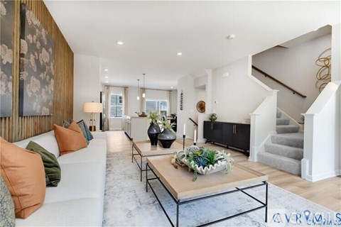A living room with a white couch and a coffee table in the center.