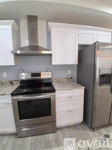 A kitchen with a stove top oven and a refrigerator.