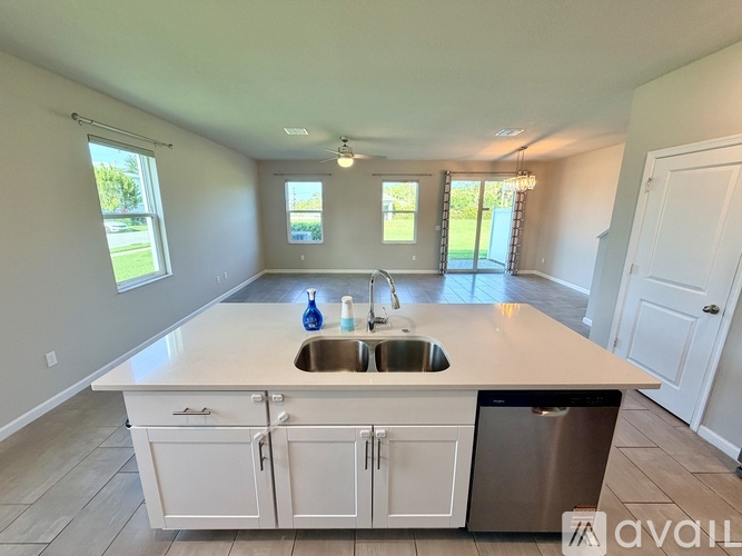 A kitchen with a sink, dishwasher, and cabinets.