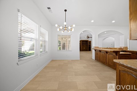 A spacious kitchen with wooden cabinets and a marble countertop.