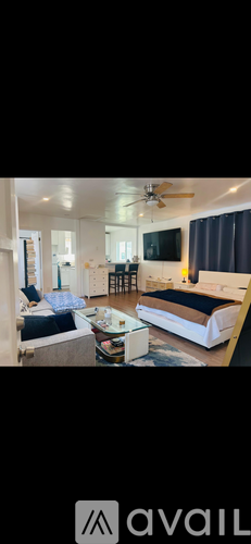 A bedroom with a bed, a couch, and a television.